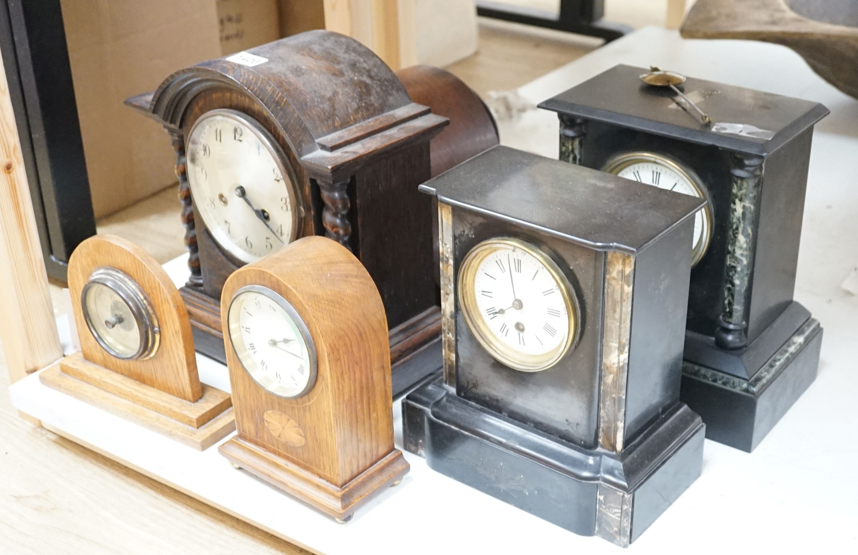 Two 19th century slate mantel clocks, three Edwardian and later wooden mantel clocks and a barometer, tallest 31 cms high.